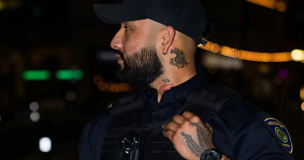 Level III armed officer in a high-visibility vest on a Houston night post